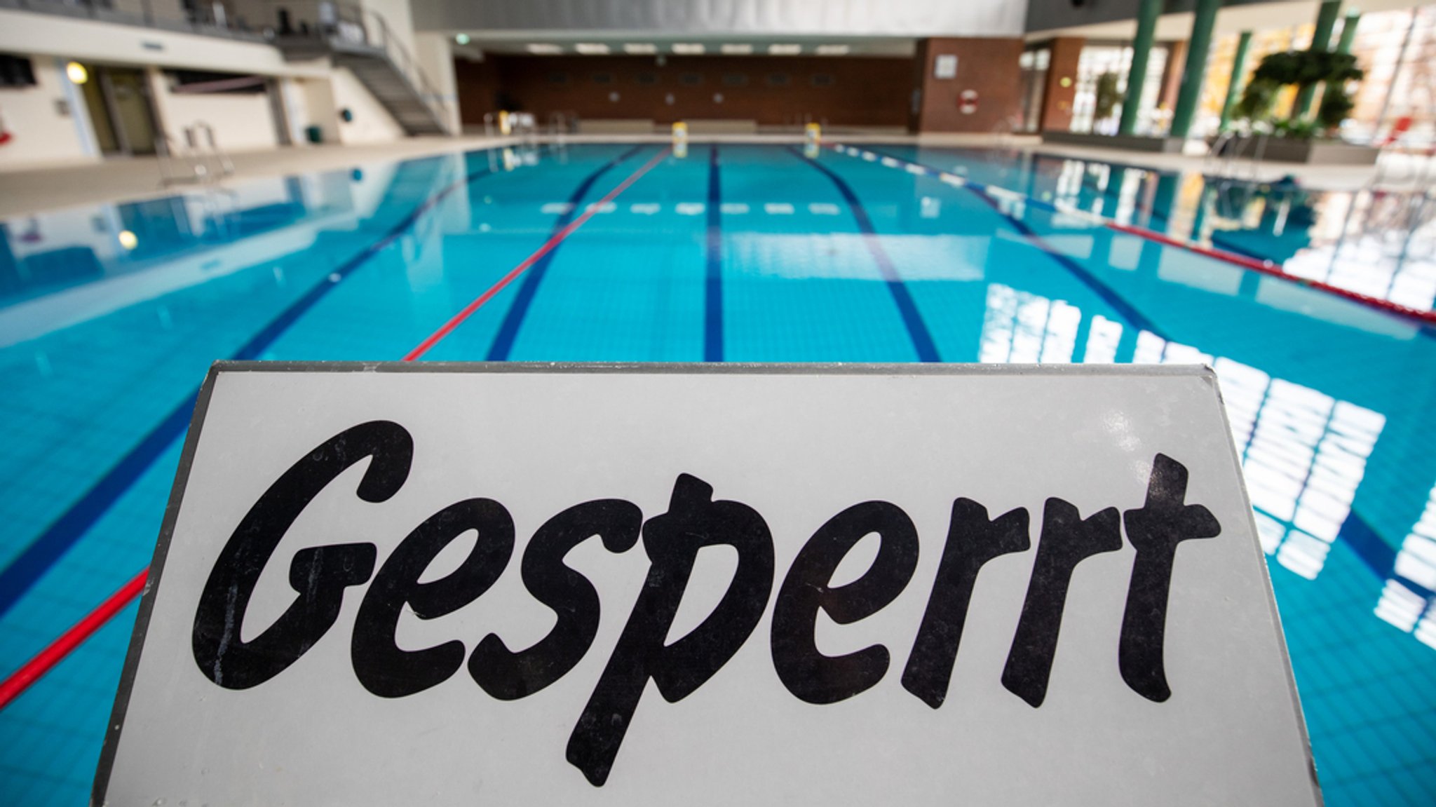 Ein "Gesperrt"-Schild am Beckenrand eines Schwimmbads.