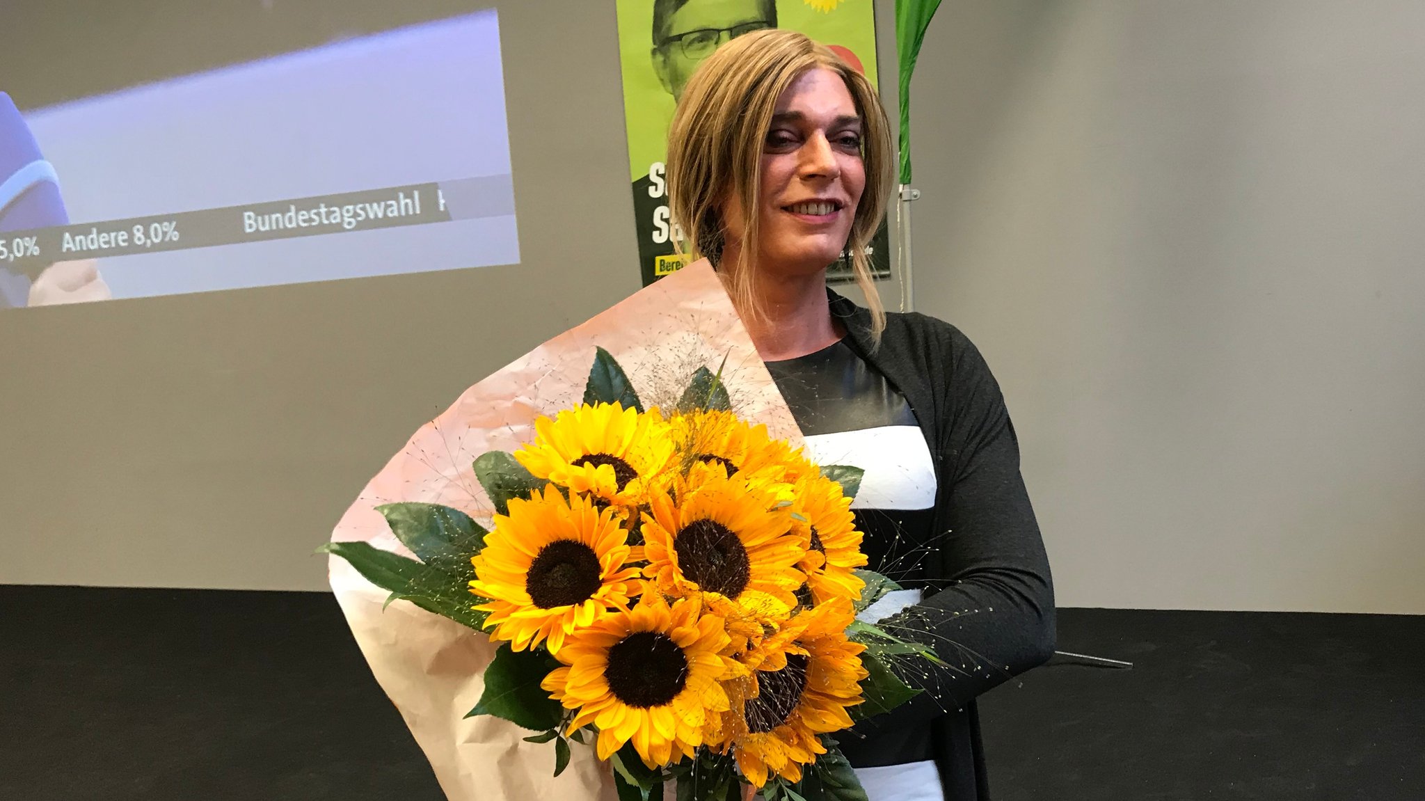 Tessa Ganserer mit einem Strauß Sonnenblumen.