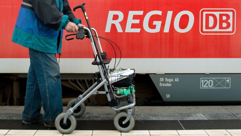 Ein Mann läuft mit seinem Rollator an einem Regionalzug der Deutschen Bahn vorbei. | Bild: picture alliance / ZB | Arno Burgi Ein Mann läuft mit seinem Rollator an einem Regionalzug der Deutschen Bahn vorbei.