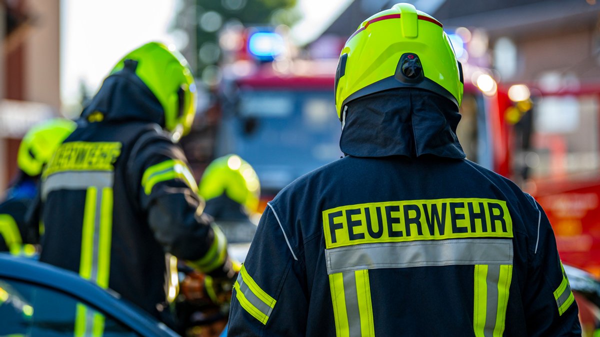 Mehrere Feuerwehrmänner mit Helmen im Einsatz (Symbolbild)