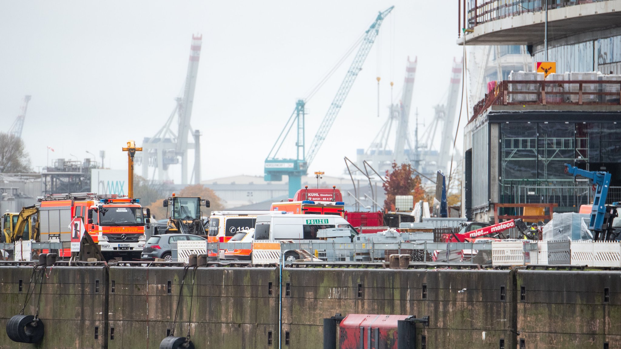 Einsatzfahrzeuge von Feuerwehr und Polizei stehen in der Hafencity auf einer Baustelle