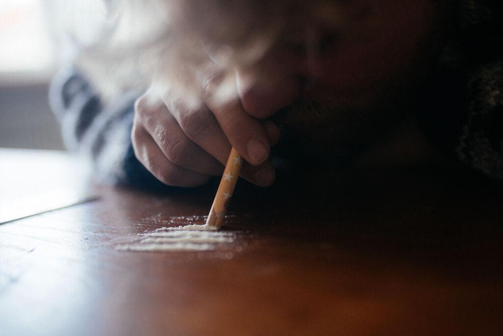 Ein Mann zieht eine Line Koks.