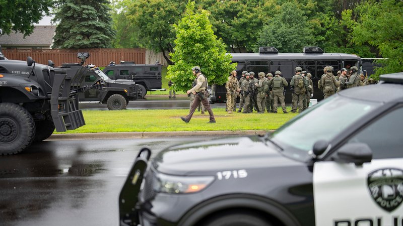 Beamte der Strafverfolgungsbehörden, darunter die örtliche Polizei, Sheriffs und das FBI, stehen weniger als eine Meile vom Unglücksort in Brooklyn Park, Minnesota entfernt, wo die demokratische US-Politikerin Melissa Hortman und ihr Ehemann erschossen wurden. | Bild: dpa-Bildfunk/Alex Kormann Beamte der Strafverfolgungsbehörden, darunter die örtliche Polizei, Sheriffs und das FBI, stehen weniger als eine Meile vom Unglücksort in Brooklyn Park, Minnesota entfernt, wo die demokratische US-Politikerin Melissa Hortman und ihr Ehemann erschossen wurden.