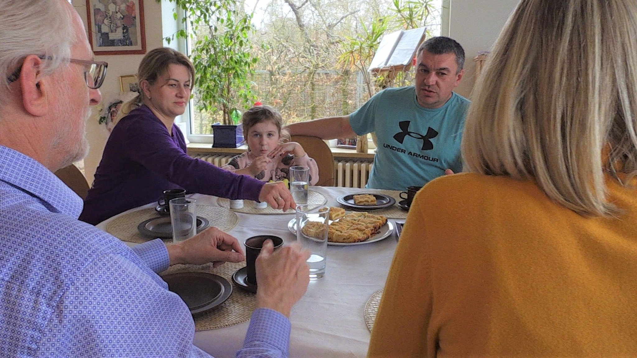 Yuliya, Anastasiya und Aleksey im Esszimmer von Familie Hebestreit in Würzburg.