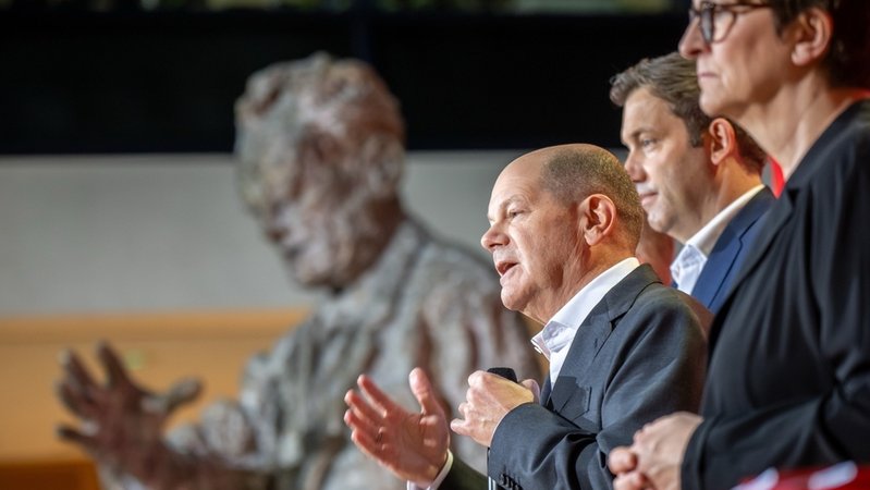Bundeskanzler Olaf Scholz (SPD), spricht zwischen Saskia Esken (r), SPD-Bundesvorsitzende, Lars Klingbeil, SPD-Bundesvorsitzender, bei der Vorstellung des Entwurf für das SPD Wahlprogramm für die Bundestagswahl 2025. | Bild: dpa-Bildfunk/Michael Kappeler Bundeskanzler Olaf Scholz (SPD), spricht zwischen Saskia Esken (r), SPD-Bundesvorsitzende, Lars Klingbeil, SPD-Bundesvorsitzender, bei der Vorstellung des Entwurf für das SPD Wahlprogramm für die Bundestagswahl 2025.