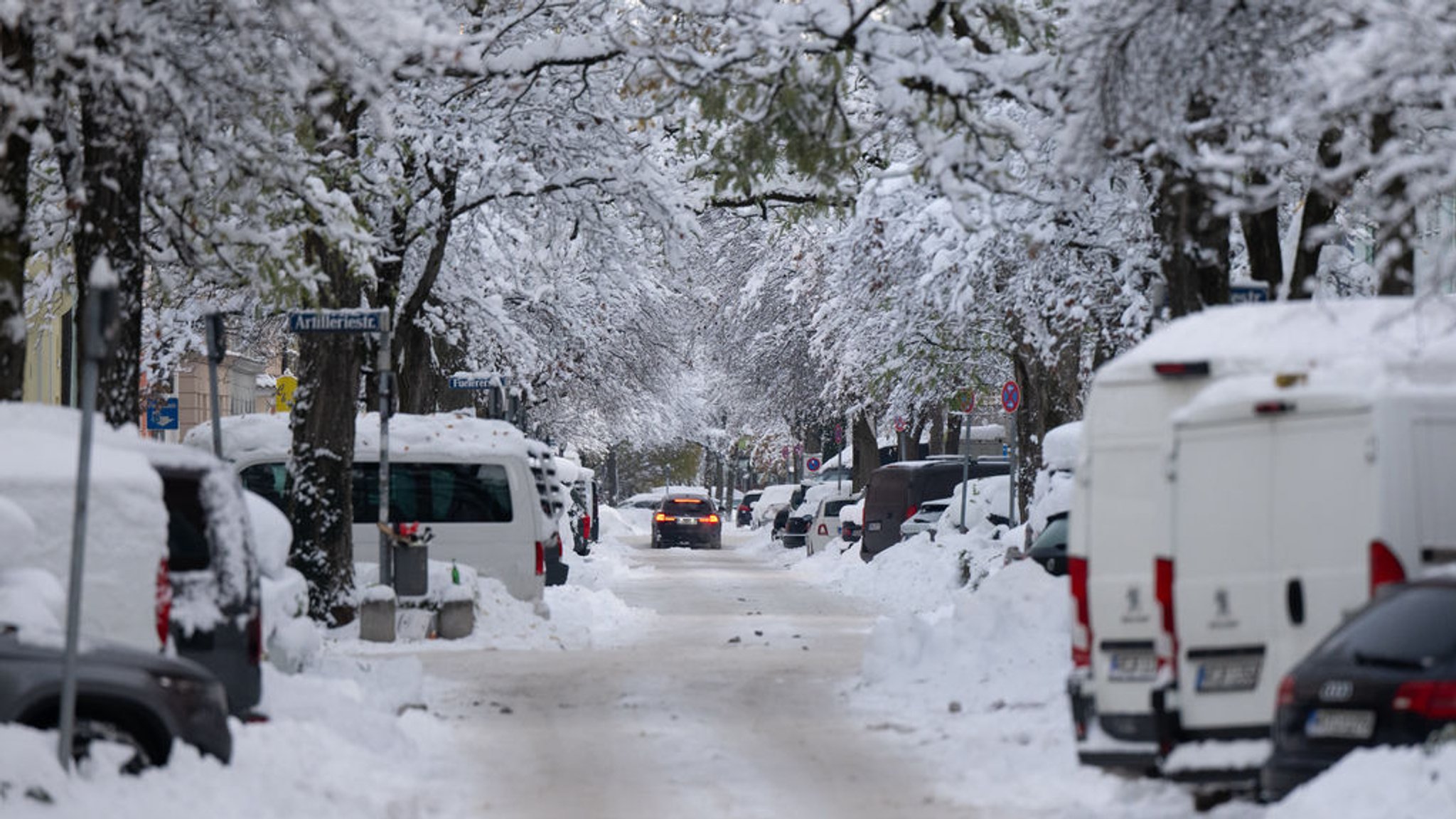 04.12.2023, Bayern, München: Ein Auto fährt über eine vereiste Straße. Schnee und Eis sorgen auf den Straßen im Süden Bayerns weiterhin für Chaos. Foto: Sven Hoppe/dpa +++ dpa-Bildfunk +++