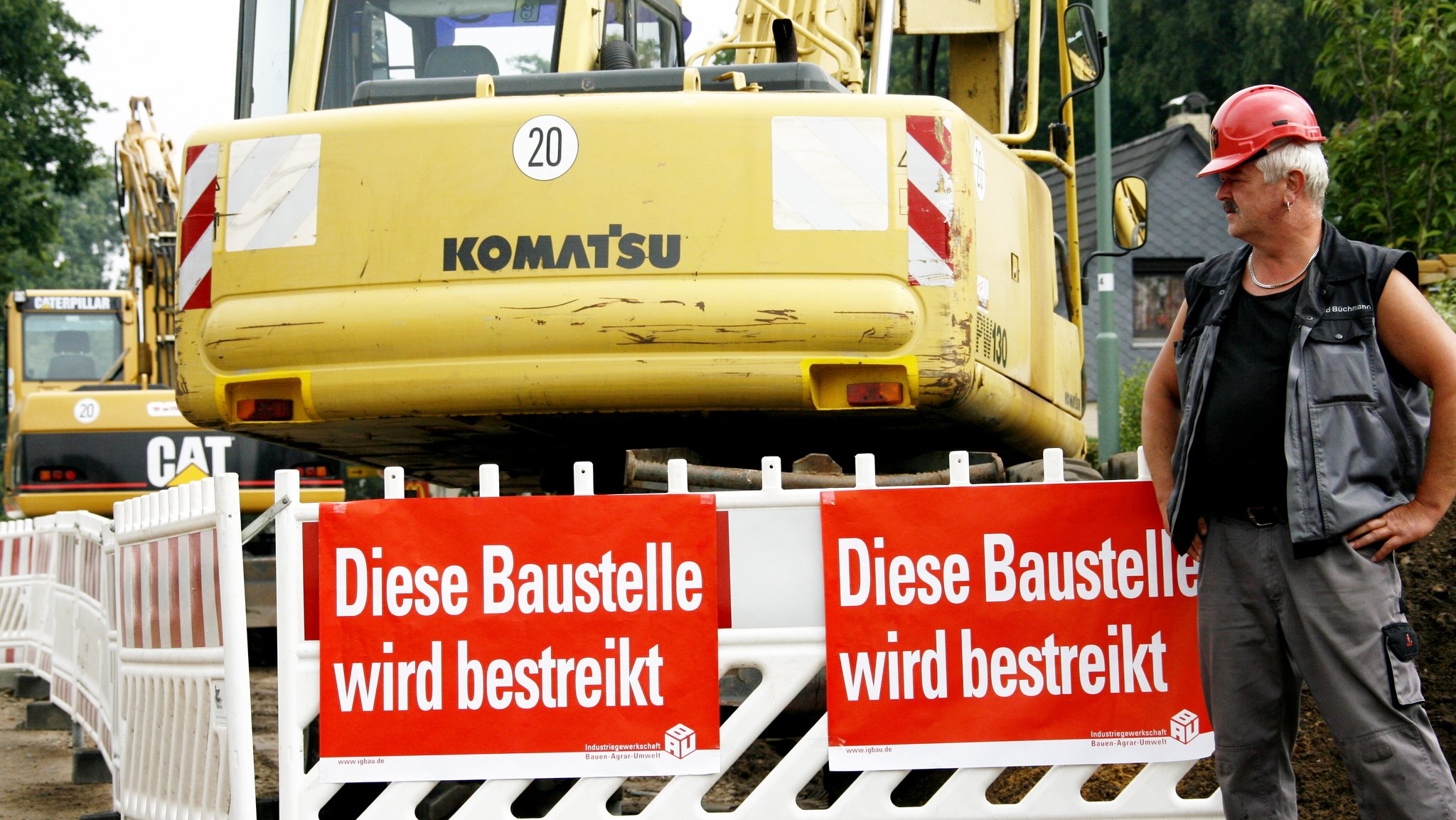 "Diese Baustelle wird bestreikt" steht auf Plakaten auf einer Baustelle