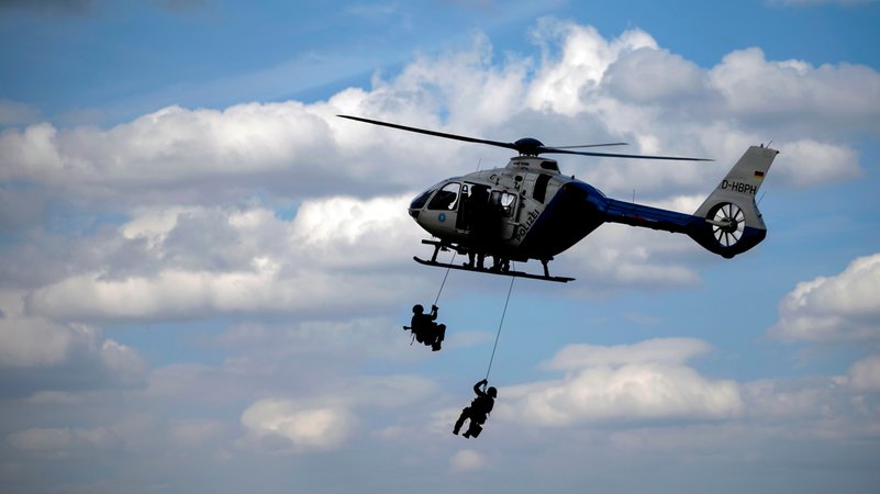 Zwei Polizisten seilen sich aus einem fliegenden Hubschrauber der bayerischen Polizei ab. (Symbolbild) | Bild: picture alliance / Panama Pictures | Dwi Anoraganingrum Zwei Polizisten seilen sich aus einem fliegenden Hubschrauber der bayerischen Polizei ab. (Symbolbild)