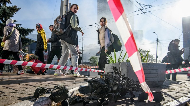 17.10.22: Passanten in Kiew schauen auf die Trümmer einer Drohne