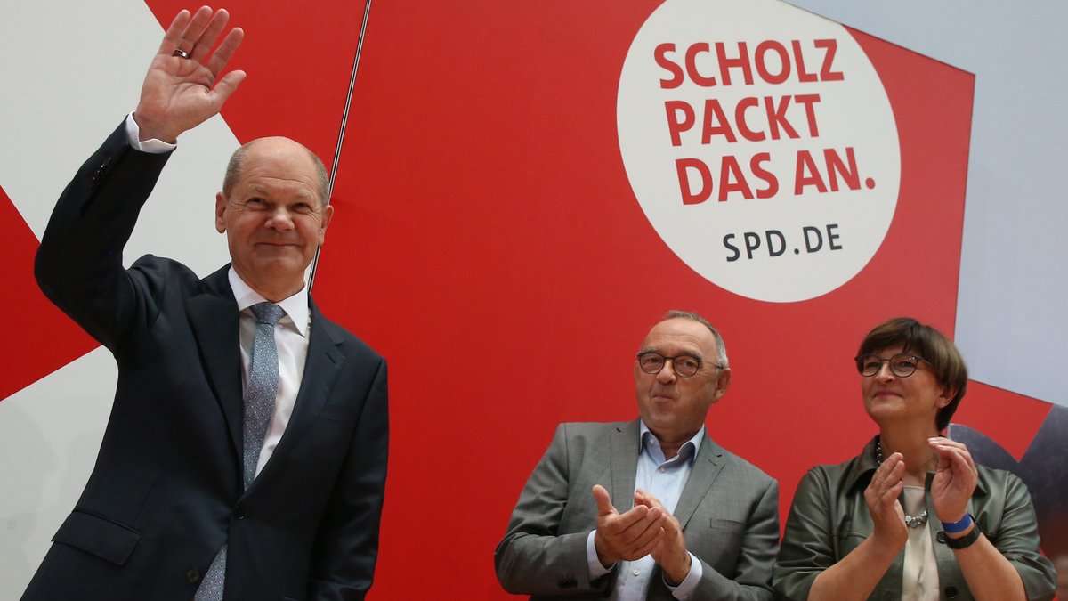 Olaf Scholz (l), Kanzlerkandidat der SPD, kommt zur Sitzung des SPD-Bundesvorstands im Willy-Brandt-Haus am Tag nach der Bundestagswahl. Im Hintergrund applaudieren die SPD-Vorsitzenden Saskia Esken und Norbert Walter-Borjans.