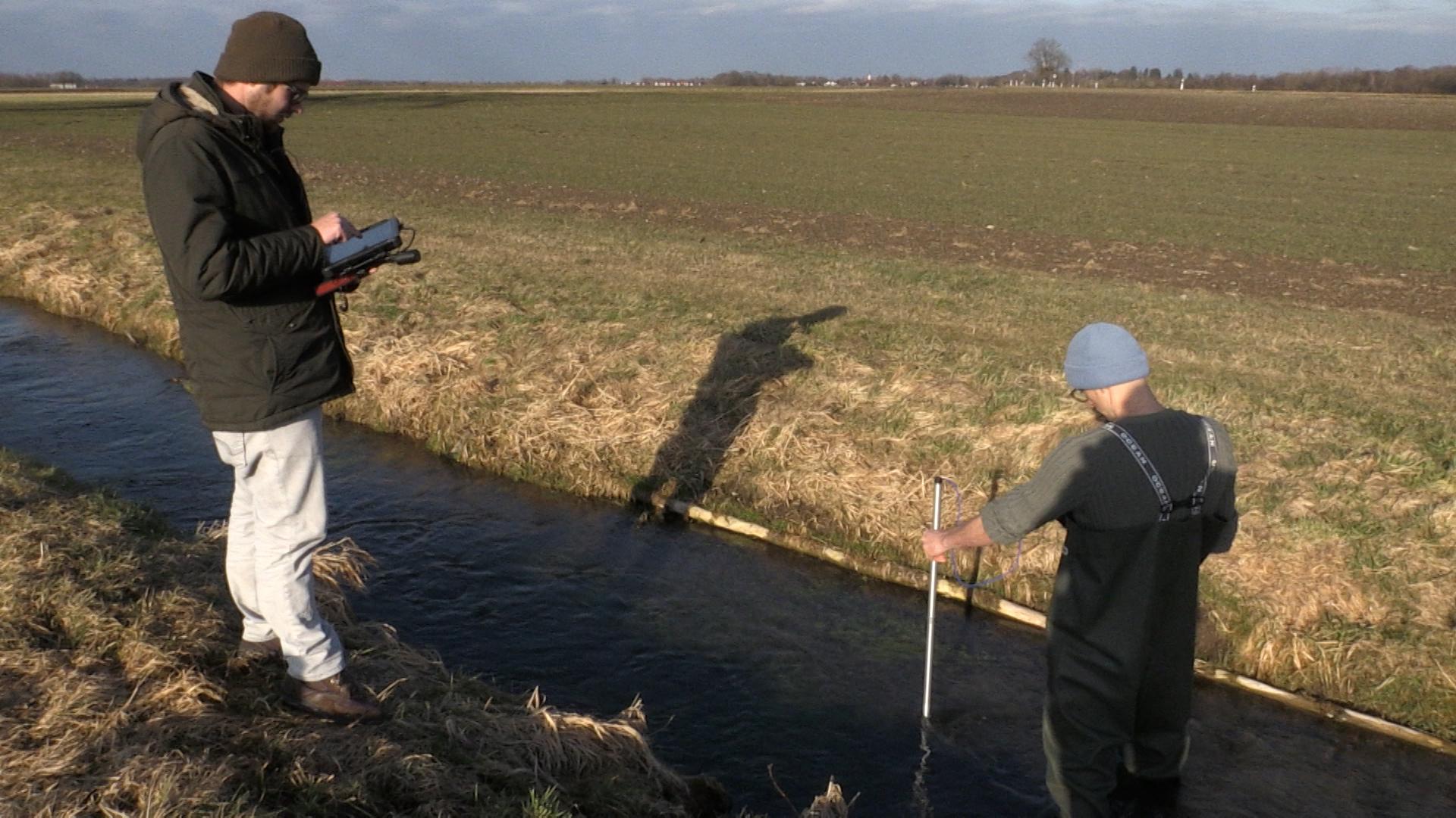 Patrick Türk und Phillip Roser vom Landesfischereiverband messen die Strömungsgeschwindigkeit und kartieren die Wassertiefe des Mühlbachs.