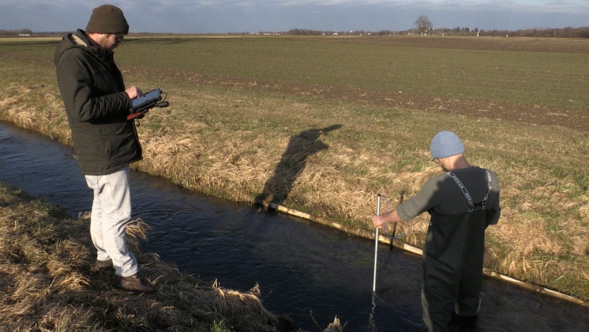 Patrick Türk und Phillip Roser vom Landesfischereiverband messen die Strömungsgeschwindigkeit und kartieren die Wassertiefe des Mühlbachs.