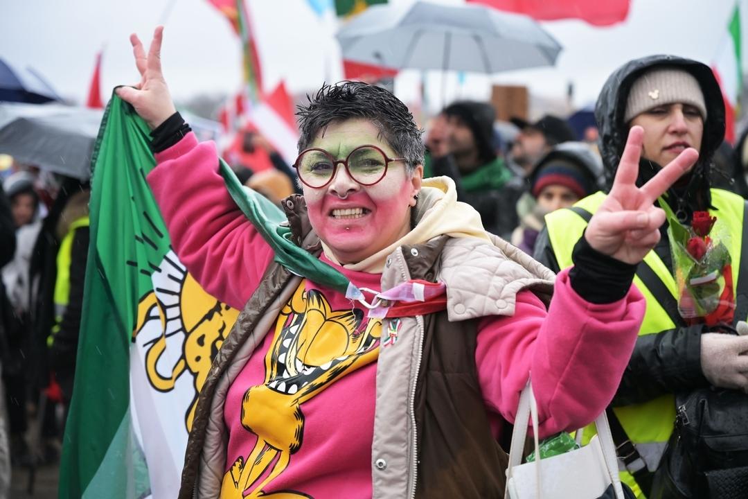 14.02.2026, Bayern, München: Eine Teilnehmerin der Demonstration "Menschenrechte und Freiheit im Iran. Internationale Solidarität mit dem iranischen Volk" anlässlich der Münchner Sicherheitskonferenz auf der Theresienwiese zeigt das Peace-Zeichen. | Bild:dpa-Bildfunk/Malin Wunderlich