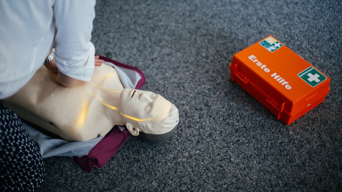 Eine Person übt die Herzdruckmassage an einer Puppe.