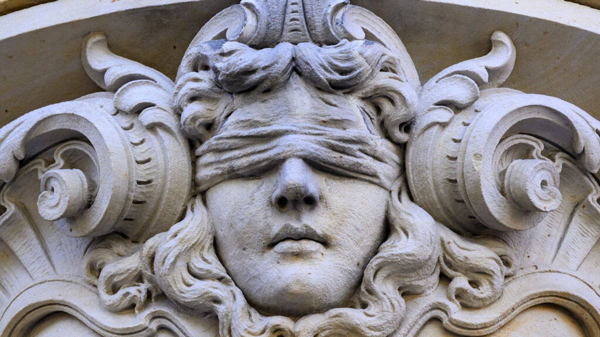 Eine Darstellung der Justitia, der römischen Göttin der Gerechtigkeit, hängt über dem Eingang eines Gerichtes. 
