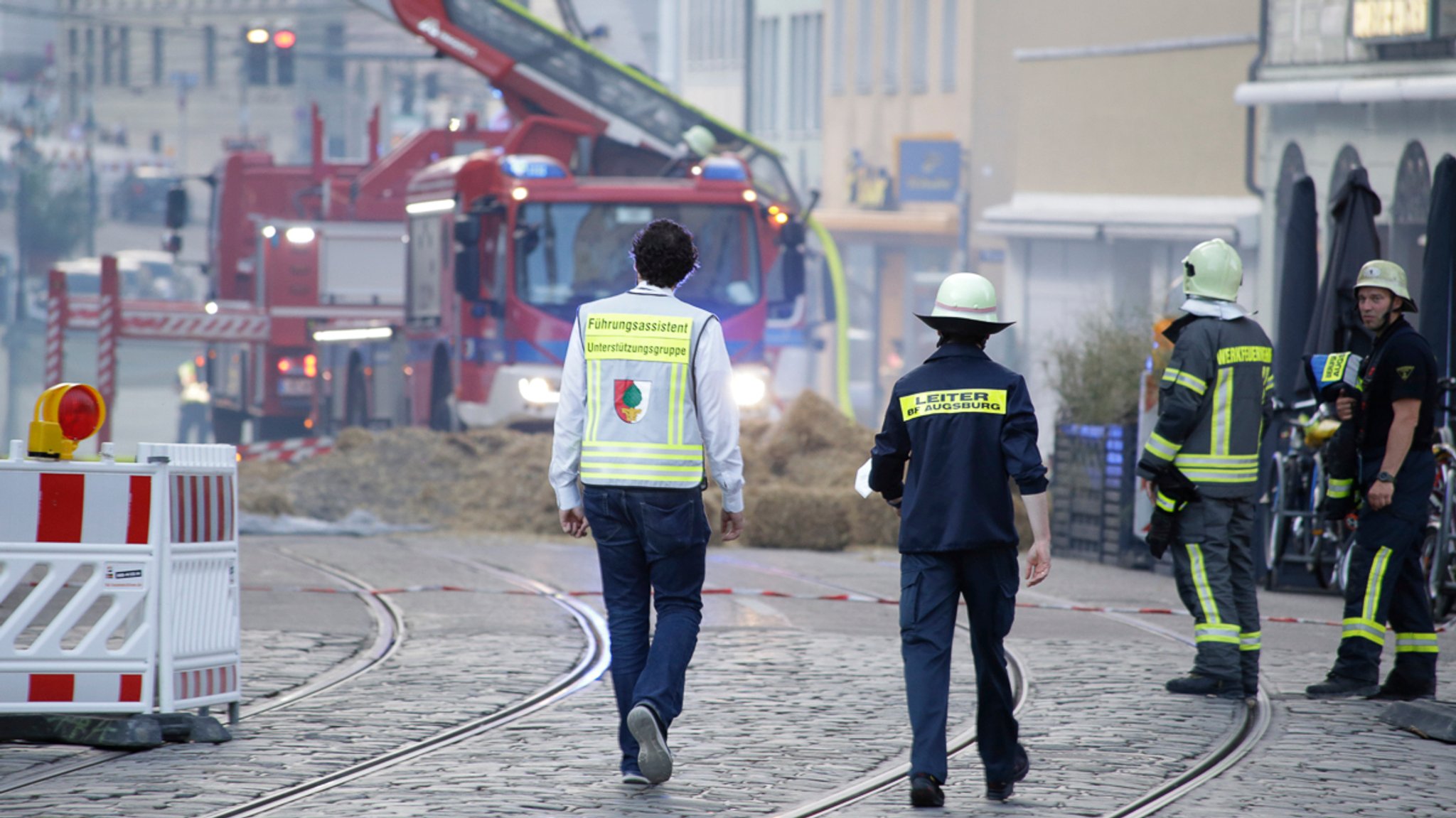 Einsatzkräfte vor der Brandruine in der Augsburger Karolinenstraße