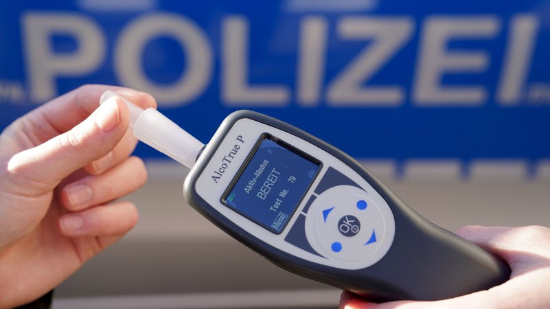 Ein Polizist hält ein Atemalkohol-Messgerät zur Überprüfung der Fahrtüchtigkeit eines Autofahrers in der Hand. | Bild: dpa-Bildfunk/Marcus Brandt Ein Polizist hält ein Atemalkohol-Messgerät zur Überprüfung der Fahrtüchtigkeit eines Autofahrers in der Hand.
