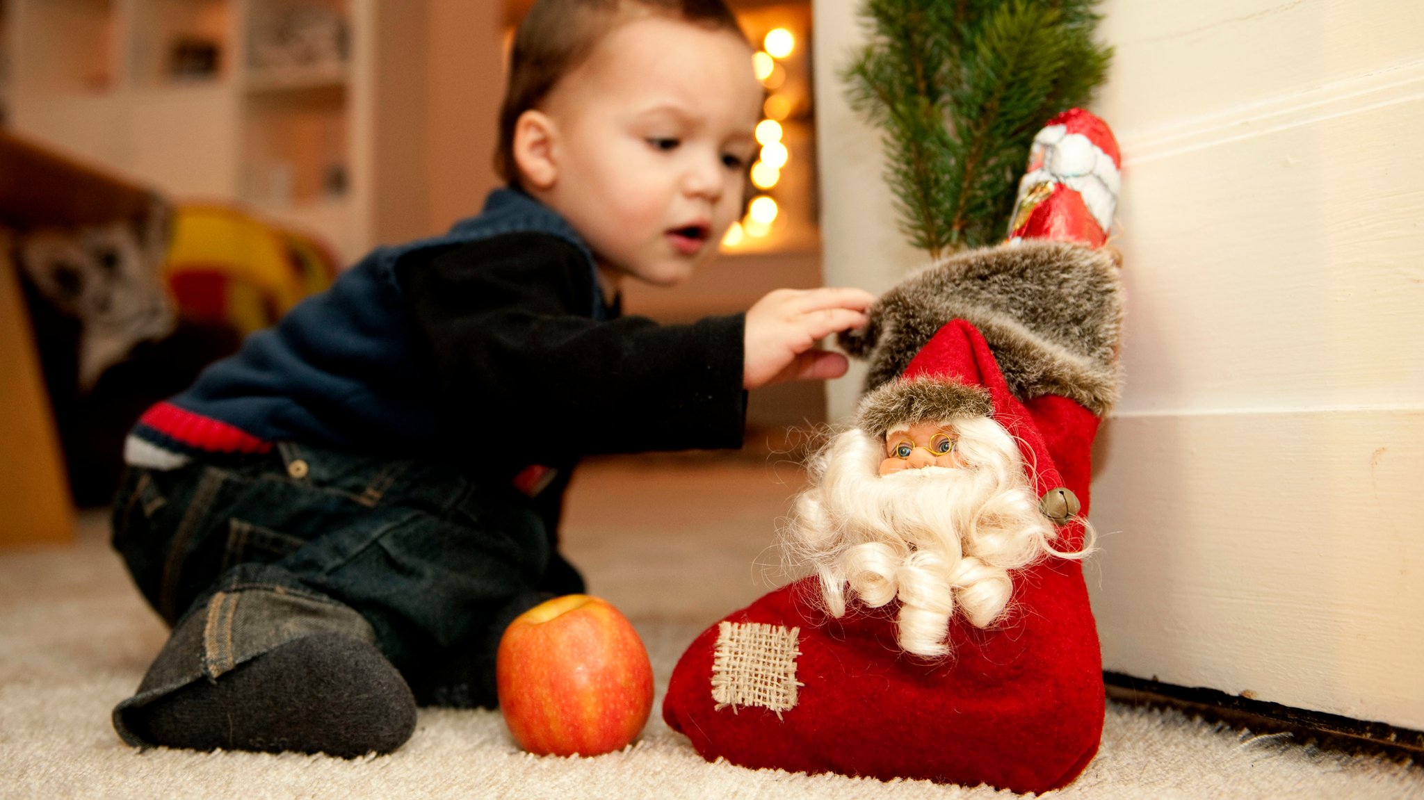 Kleinkind greift zu einem Stoffstiefel mit Nikolaus drauf und Schokonikolaus im Stiefel. | Bild: picture alliance / dpa | Robert Schlesinger Kleinkind greift zu einem Stoffstiefel mit Nikolaus drauf und Schokonikolaus im Stiefel.