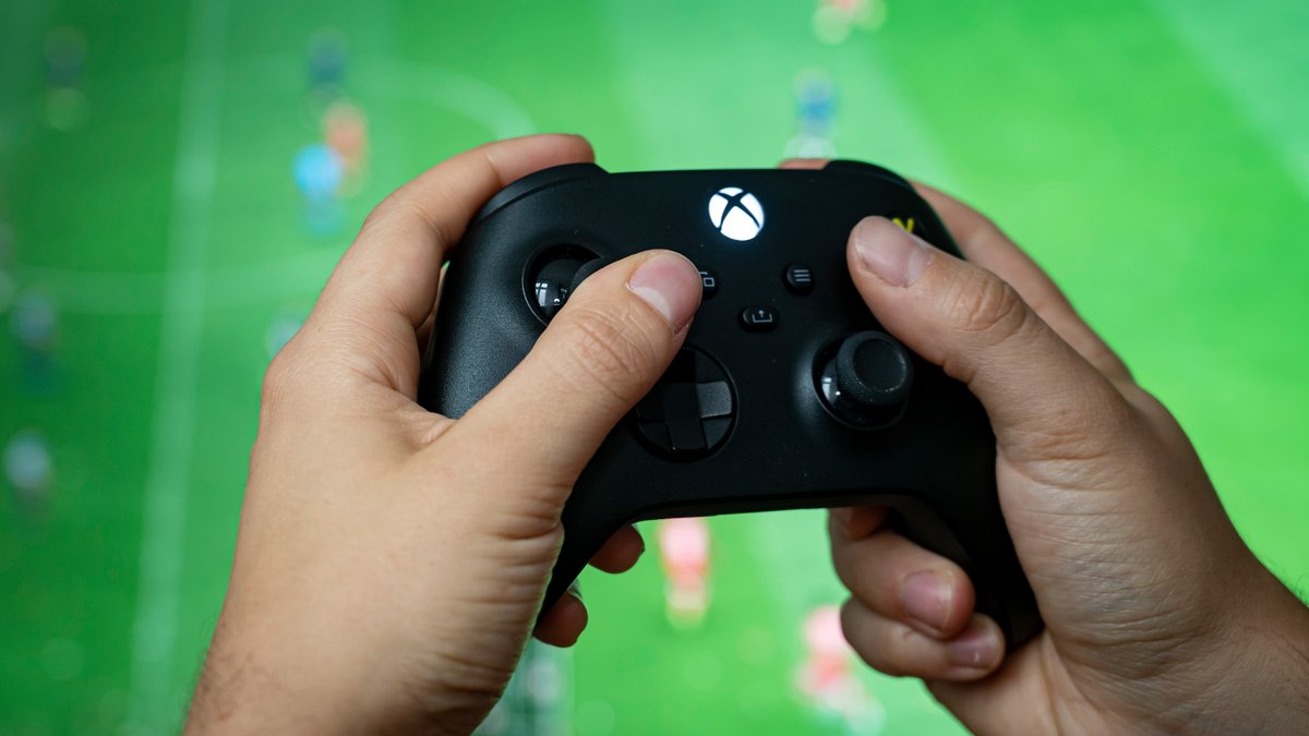 Ein Mann hält einen Kontroller der Spielekonsole Xbox Series X in der Hand.