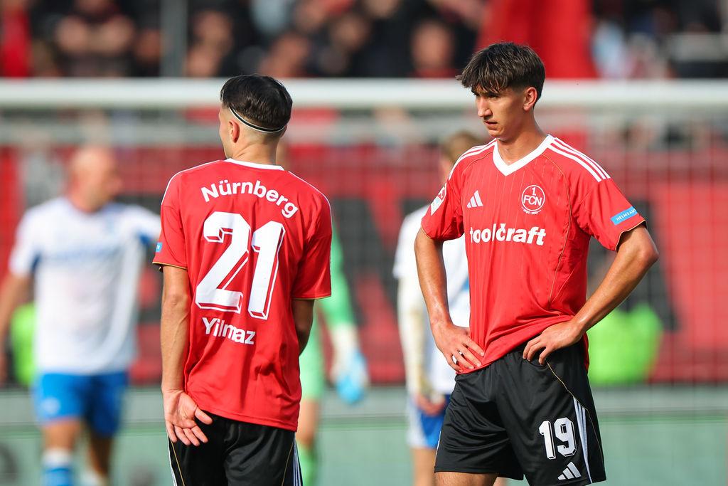 28.09.2025, Bayern, Nürnberg: Fußball, 2. Bundesliga, 1. FC Nürnberg - Hertha BSC, 7. Spieltag im Max-Morlock-Stadion. Berkay Yilmaz (1. FC Nürnberg, l) und Eryk Grzywacz (1. FC Nürnberg) stehen nach dem Abpfiff auf dem Platz. Das Spiel endete 0:3. Foto: Daniel Karmann/dpa - WICHTIGER HINWEIS: Gemäß den Vorgaben der DFL Deutsche Fußball Liga bzw. des DFB Deutscher Fußball-Bund ist es untersagt, in dem Stadion und/oder vom Spiel angefertigte Fotoaufnahmen in Form von Sequenzbildern und/oder videoähnlichen Fotostrecken zu verwerten bzw. verwerten zu lassen. +++ dpa-Bildfunk +++