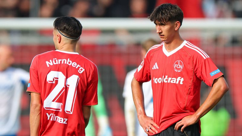 28.09.2025, Bayern, Nürnberg: Fußball, 2. Bundesliga, 1. FC Nürnberg - Hertha BSC, 7. Spieltag im Max-Morlock-Stadion. Berkay Yilmaz (1. FC Nürnberg, l) und Eryk Grzywacz (1. FC Nürnberg) stehen nach dem Abpfiff auf dem Platz. Das Spiel endete 0:3. Foto: Daniel Karmann/dpa - WICHTIGER HINWEIS: Gemäß den Vorgaben der DFL Deutsche Fußball Liga bzw. des DFB Deutscher Fußball-Bund ist es untersagt, in dem Stadion und/oder vom Spiel angefertigte Fotoaufnahmen in Form von Sequenzbildern und/oder videoähnlichen Fotostrecken zu verwerten bzw. verwerten zu lassen. +++ dpa-Bildfunk +++ | Bild: dpa-Bildfunk/Daniel Karmann 28.09.2025, Bayern, Nürnberg: Fußball, 2. Bundesliga, 1. FC Nürnberg - Hertha BSC, 7. Spieltag im Max-Morlock-Stadion. Berkay Yilmaz (1. FC Nürnberg, l) und Eryk Grzywacz (1. FC Nürnberg) stehen nach dem Abpfiff auf dem Platz. Das Spiel endete 0:3. Foto: Daniel Karmann/dpa - WICHTIGER HINWEIS: Gemäß den Vorgaben der DFL Deutsche Fußball Liga bzw. des DFB Deutscher Fußball-Bund ist es untersagt, in dem Stadion und/oder vom Spiel angefertigte Fotoaufnahmen in Form von Sequenzbildern und/oder videoähnlichen Fotostrecken zu verwerten bzw. verwerten zu lassen. +++ dpa-Bildfunk +++
