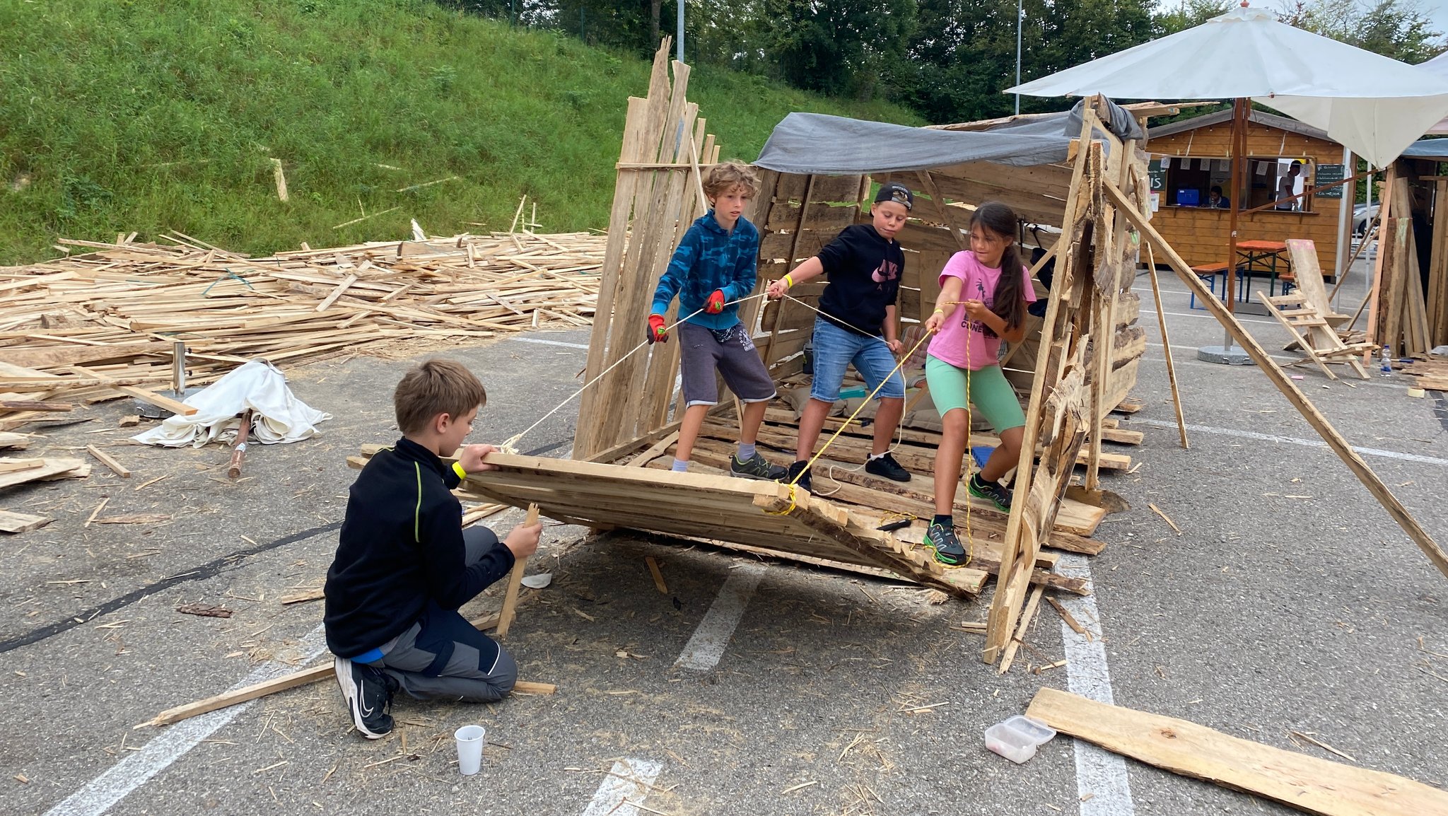 Jakob, Benni, Domi und Maria bauen gemeinsam eine Hütte auf dem Abenteuerspielplatz Aschheim