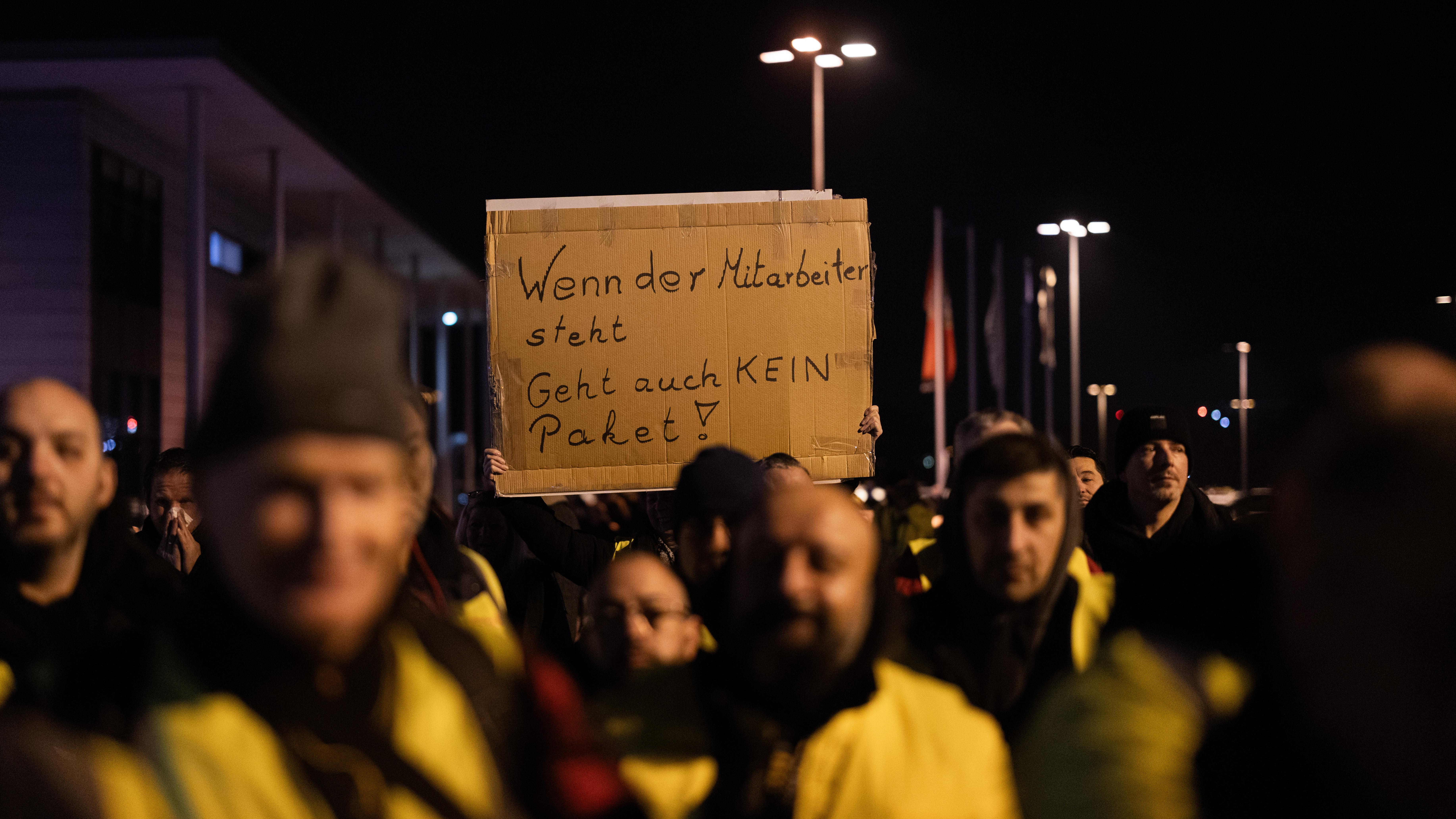 ARCHIV (12.12.2023) - Symbolbild für Streik in der Logistikbranche. Streikende von UPS und Fedex stehen bei einem Warnstreik auf einem Parkplatz am Flughafen Köln/Bonn.
