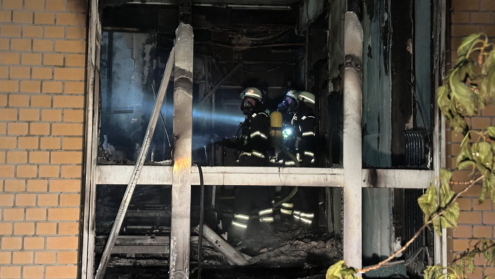 Feuerwehrleute mit Atemschutzgerät arbeiten in einem ausgebrannten Raum im Erdgeschoss im Marienkrankenhaus in Hamburg