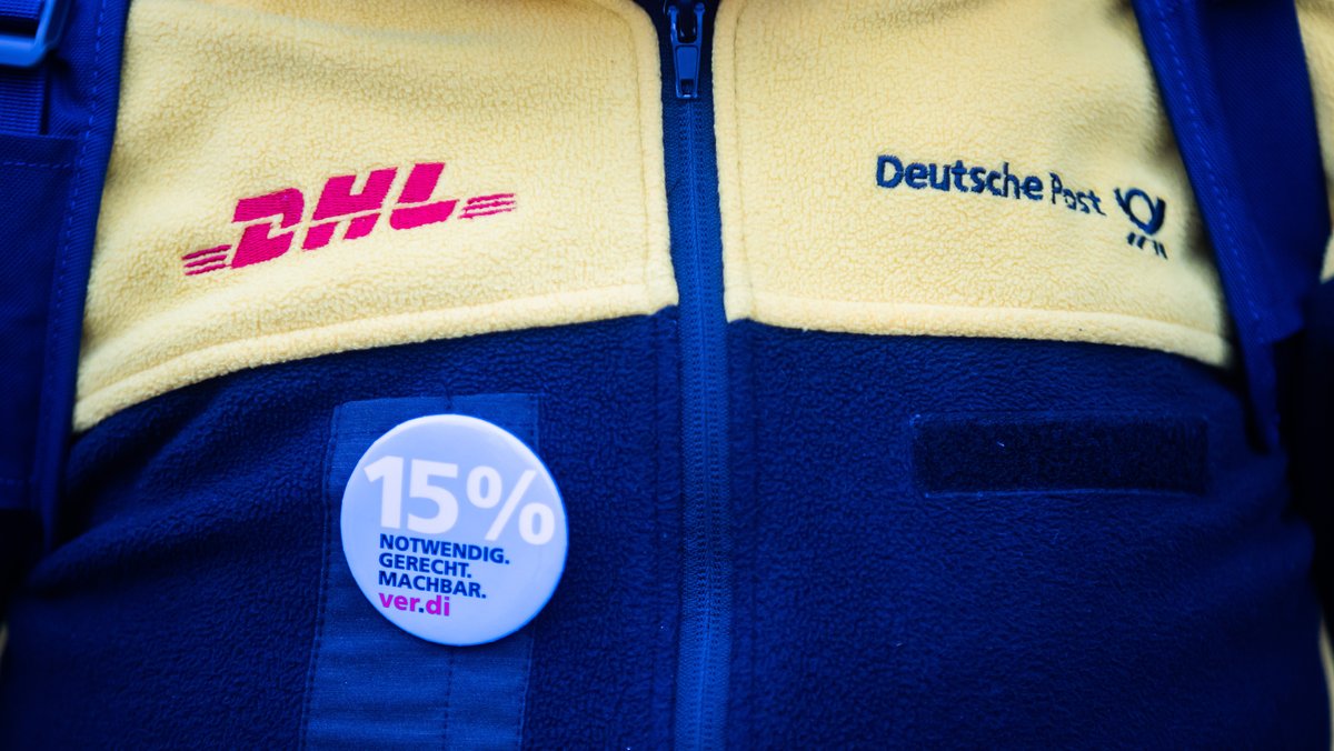 Eine Teilnehmerin eines Streiks von Post-Beschäftigten trägt vor dem Sitz des Verdi Landesbezirks Berlin-Brandenburg Dienstkleidung und einen 15%-Anstecker.  (Archiv: 26.01.2023)