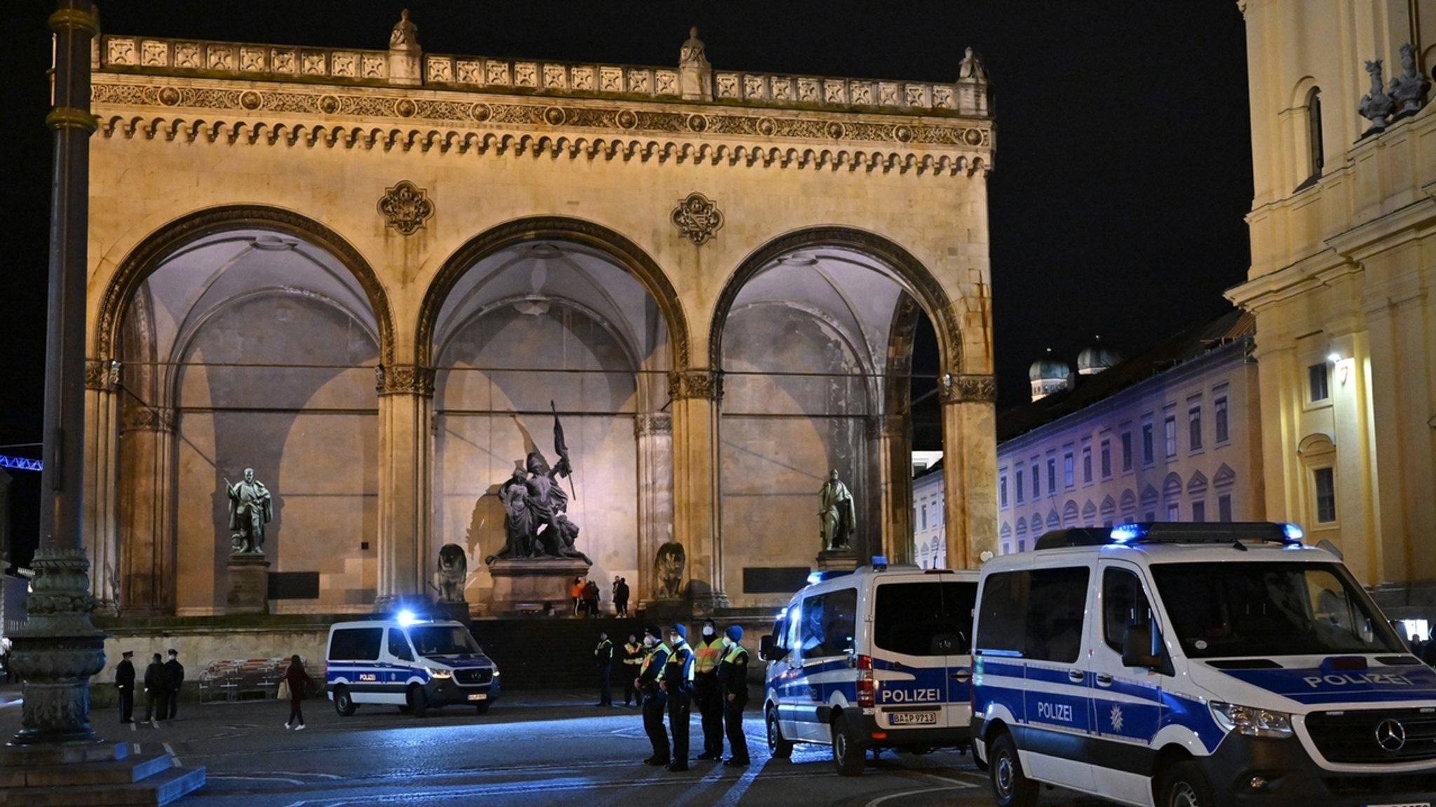 30.12.2021, München: Einsatzkräfte der Polizei stehen auf dem Odeonsplatz vor der Feldherrnhalle, falls sich "Spaziergänger" versammeln sollten. Immer mehr bayerische Kommunen verbieten unangemeldete Versammlungen und «Spaziergänge» zum Protest gegen Corona-Maßnahmen oder verfügen strenge Auflagen.