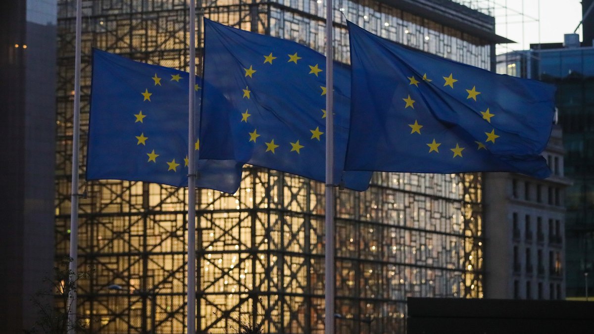 Das Gebäude des Europäischen Rates in Brüssel. Im Vordergrund wehen Flaggen der Europäischen Union.