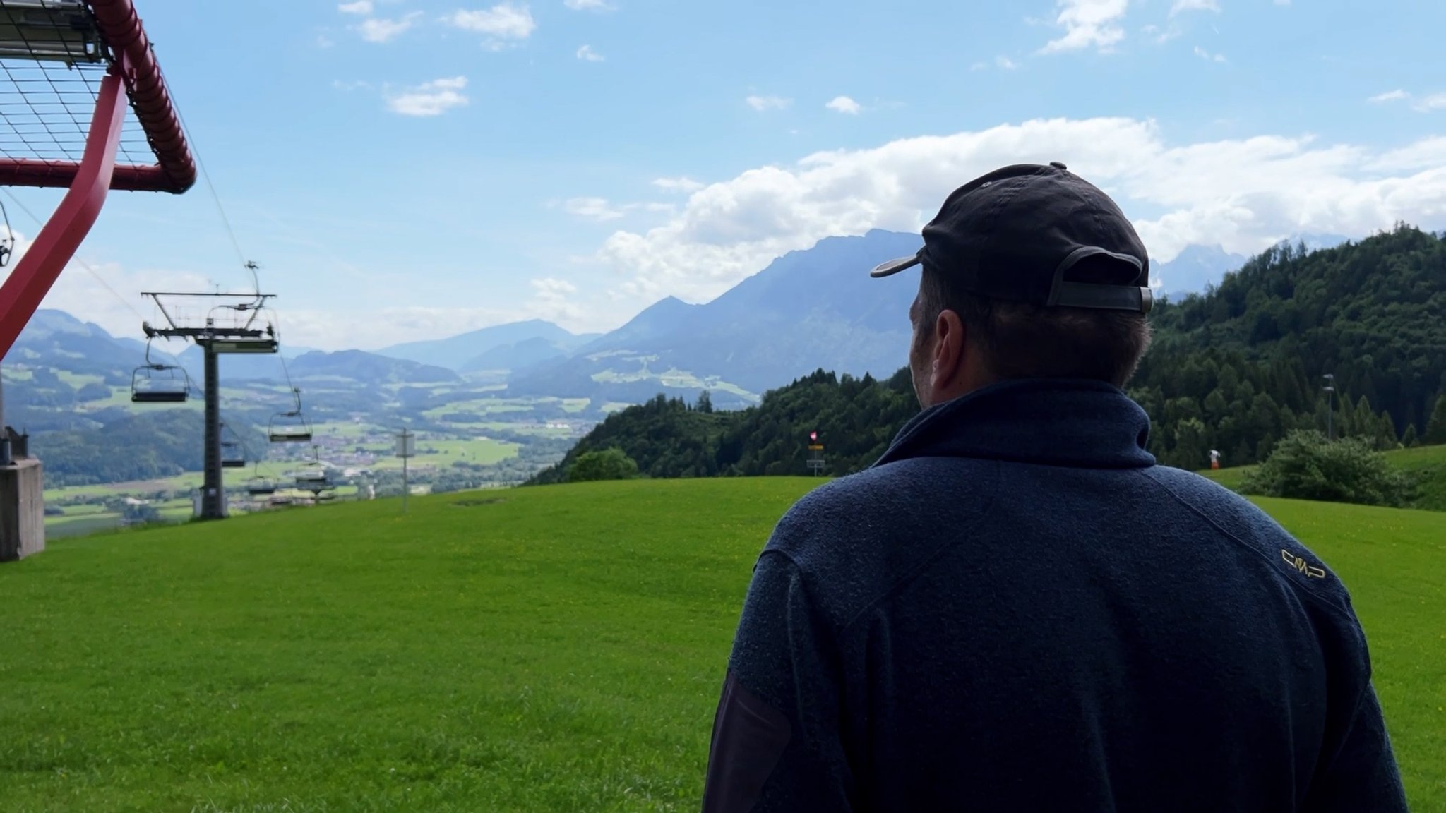 Ein Mann steht an der Bergstation der Hocheck-Bergbahn und blickt hinunter ins Tal. | Bild: BR/Julia Binder Ein Mann steht an der Bergstation der Hocheck-Bergbahn und blickt hinunter ins Tal.