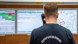 Einsatzsachbearbeiter steht in einer Leitstelle und nimmt einen Notruf entgegen. | Bild:picture alliance/ Frank Rumpenhorst