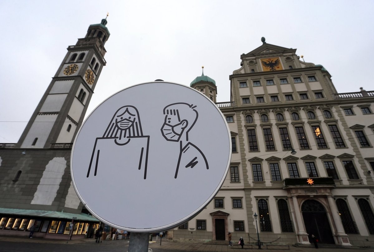 ARCHIV - 05.01.2021, Bayern, Augsburg: Ein Schild weist auf dem Rathausplatz auf Maskenpflicht hin. (zu dpa «Maskenpflicht bei Sitzungen? Gemeinderäte dürfen selbst entscheiden») Foto: Karl-Josef Hildenbrand/dpa +++ dpa-Bildfunk +++