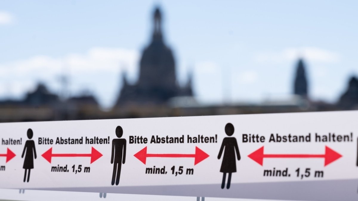 Sachsen, Dresden: Ein Absperrband mit der Aufschrift "Bitte Abstand halten" hängt am Zugang zu einer Terrasse vor einem Restaurant. 
