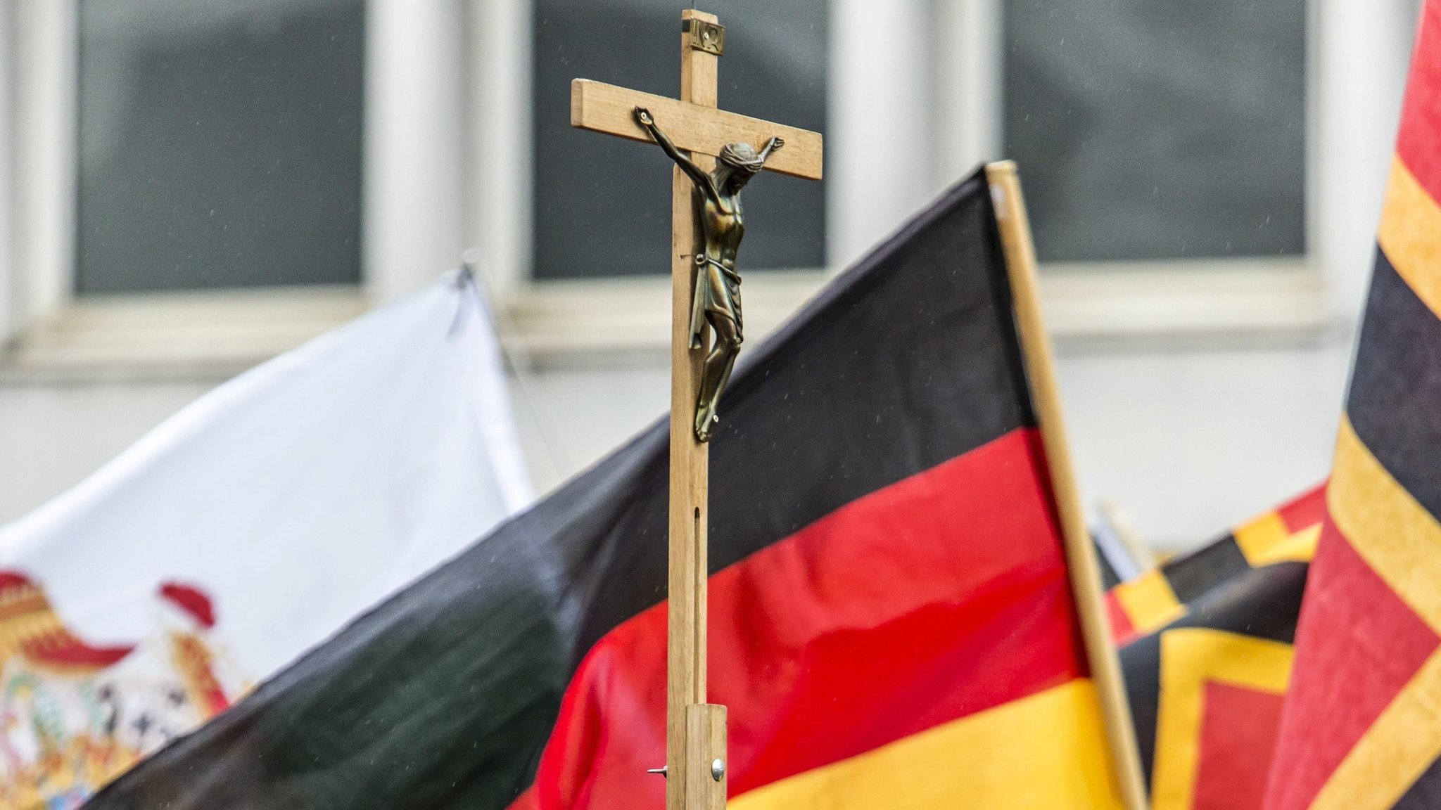 Auf einer PEGIDA-Demonstration wird neben Deutschlandfahnen auch ein Kreuz mitgetragen.