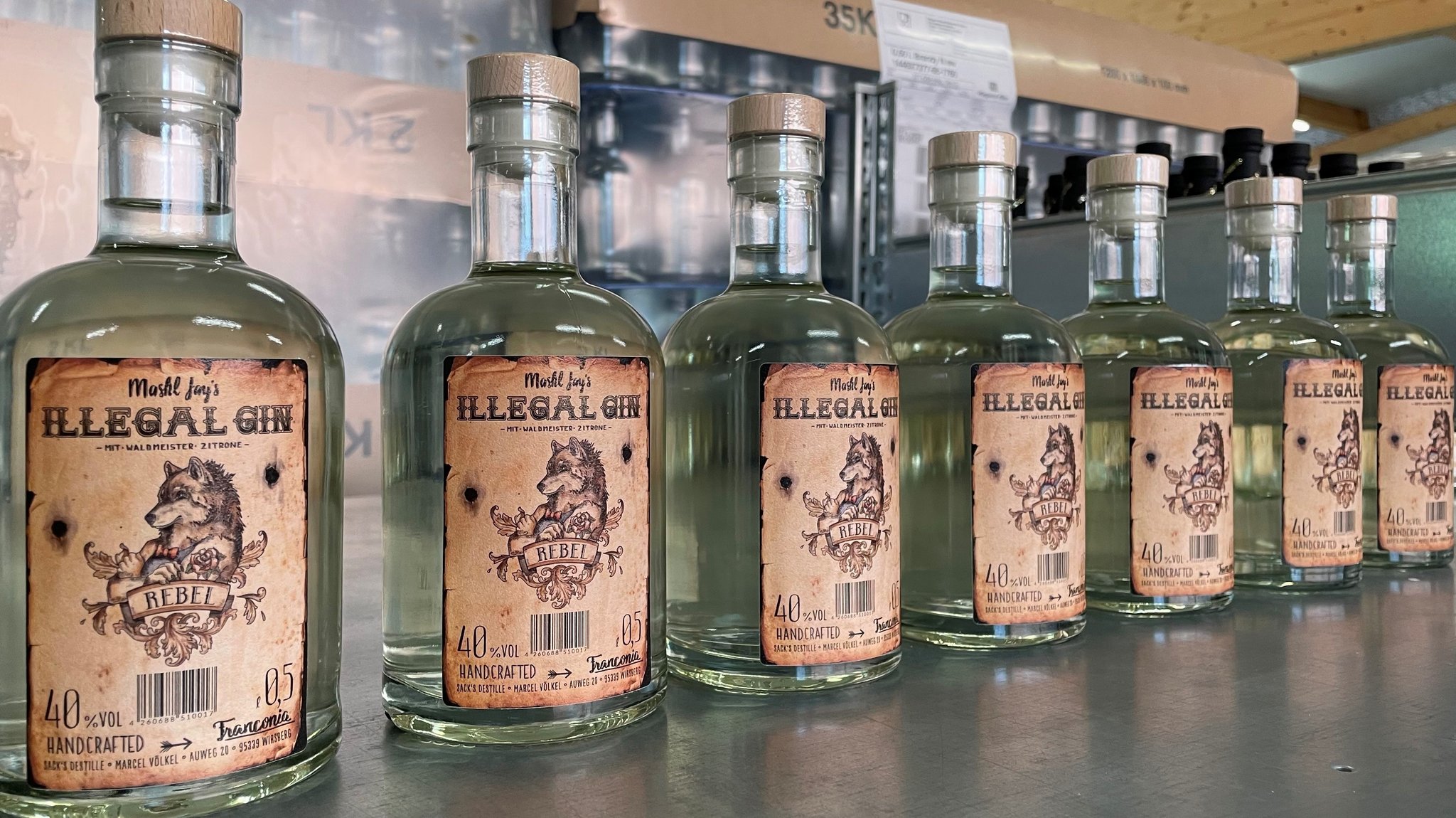 Sieben Flaschen Illegal Gin in einer Reihe. 