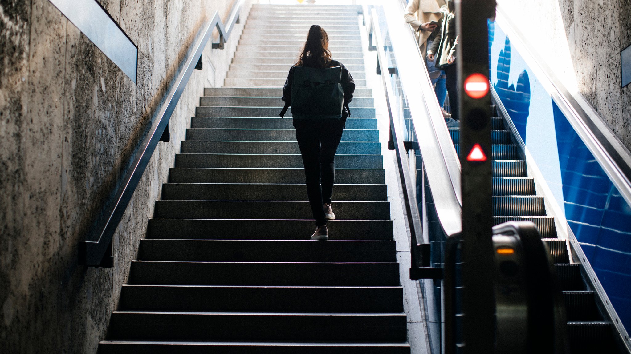Eine Frau nimmt die Treppe an einer U-Bahnstation. 