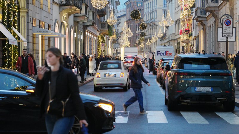 Straßenverkehr vor einer beliebten Einkaufsstraße in Mailand. | Bild: picture alliance / ipa-agency | Duilio Piaggesi Straßenverkehr vor einer beliebten Einkaufsstraße in Mailand.