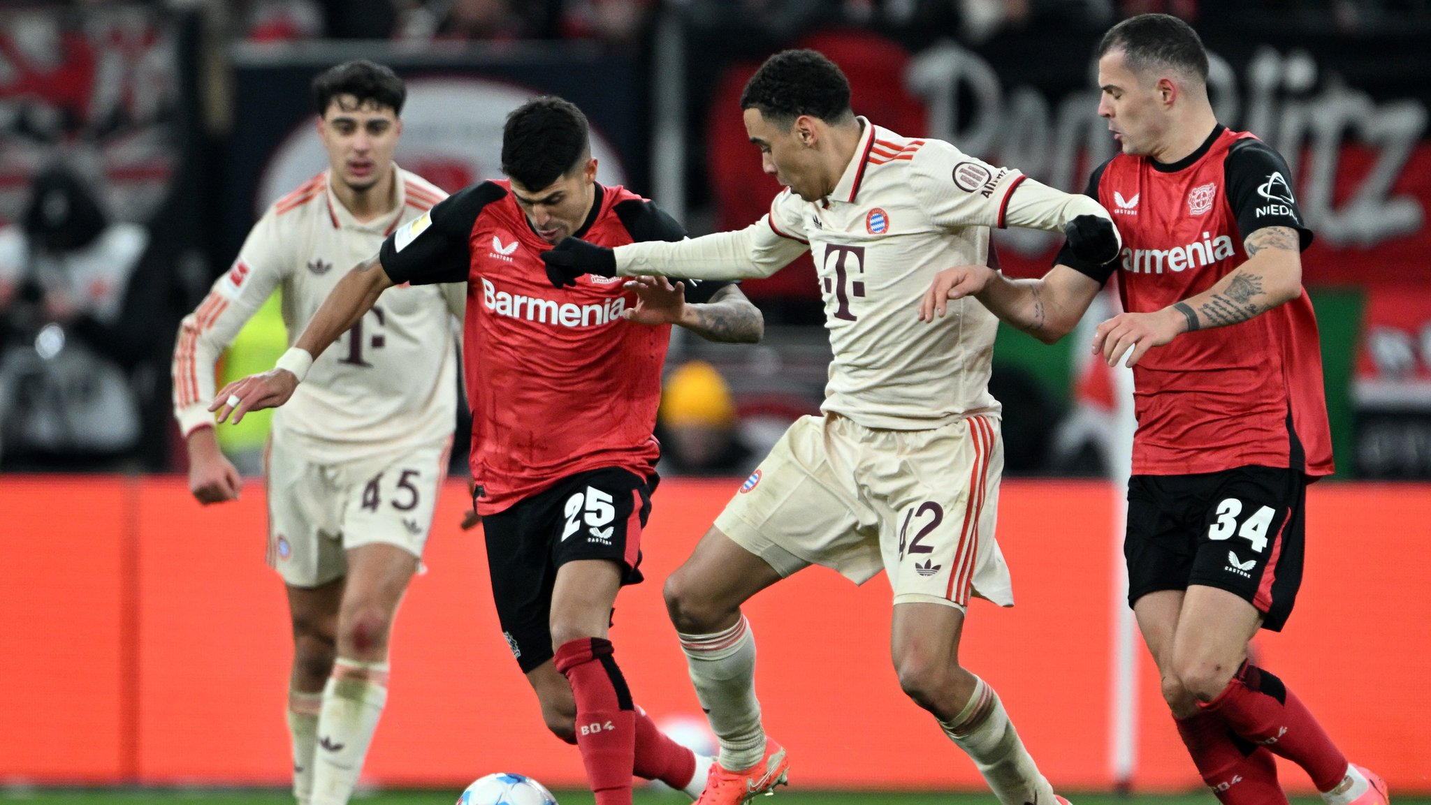 15.02.2025, Nordrhein-Westfalen, Leverkusen: Fußball: Bundesliga, Bayer Leverkusen - Bayern München, 22. Spieltag, BayArena. Leverkusens Exequiel Palacios (l) und Bayerns Jamal Musiala kämpfen um den Ball. Foto: Federico Gambarini/dpa - WICHTIGER HINWEIS: Gemäß den Vorgaben der DFL Deutsche Fußball Liga bzw. des DFB Deutscher Fußball-Bund ist es untersagt, in dem Stadion und/oder vom Spiel angefertigte Fotoaufnahmen in Form von Sequenzbildern und/oder videoähnlichen Fotostrecken zu verwerten bzw. verwerten zu lassen. +++ dpa-Bildfunk +++