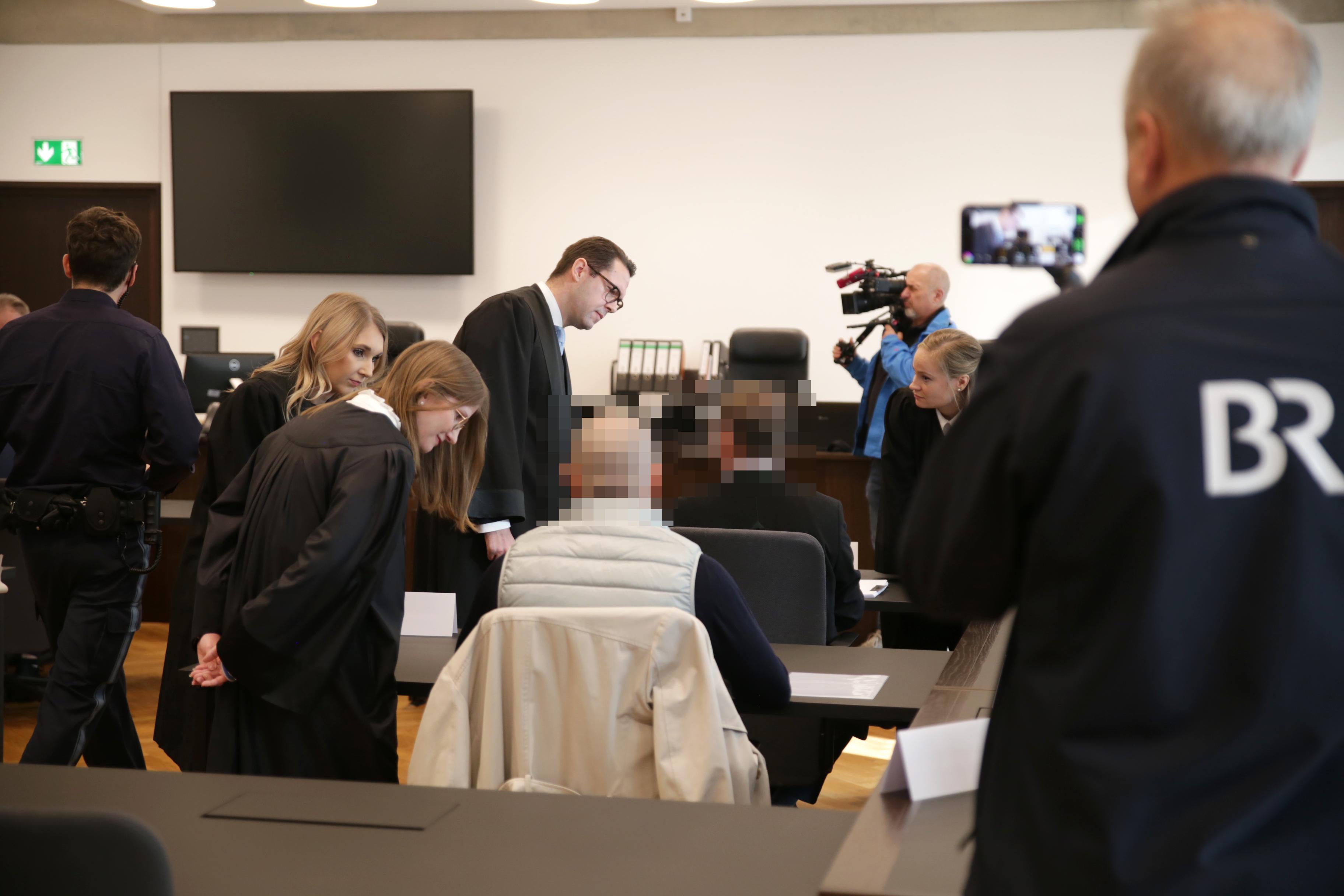 Menschen und Kamerateams in einem Gerichtssaal