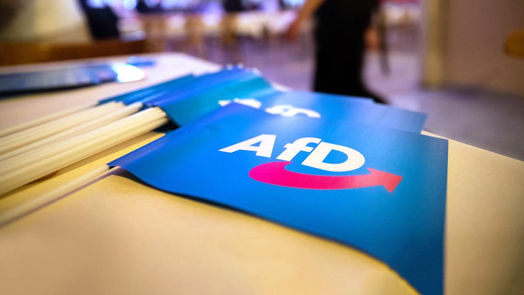Papierfähnchen mit dem Logo der AfD liegen auf einem Tisch an einem Landesparteitag.
