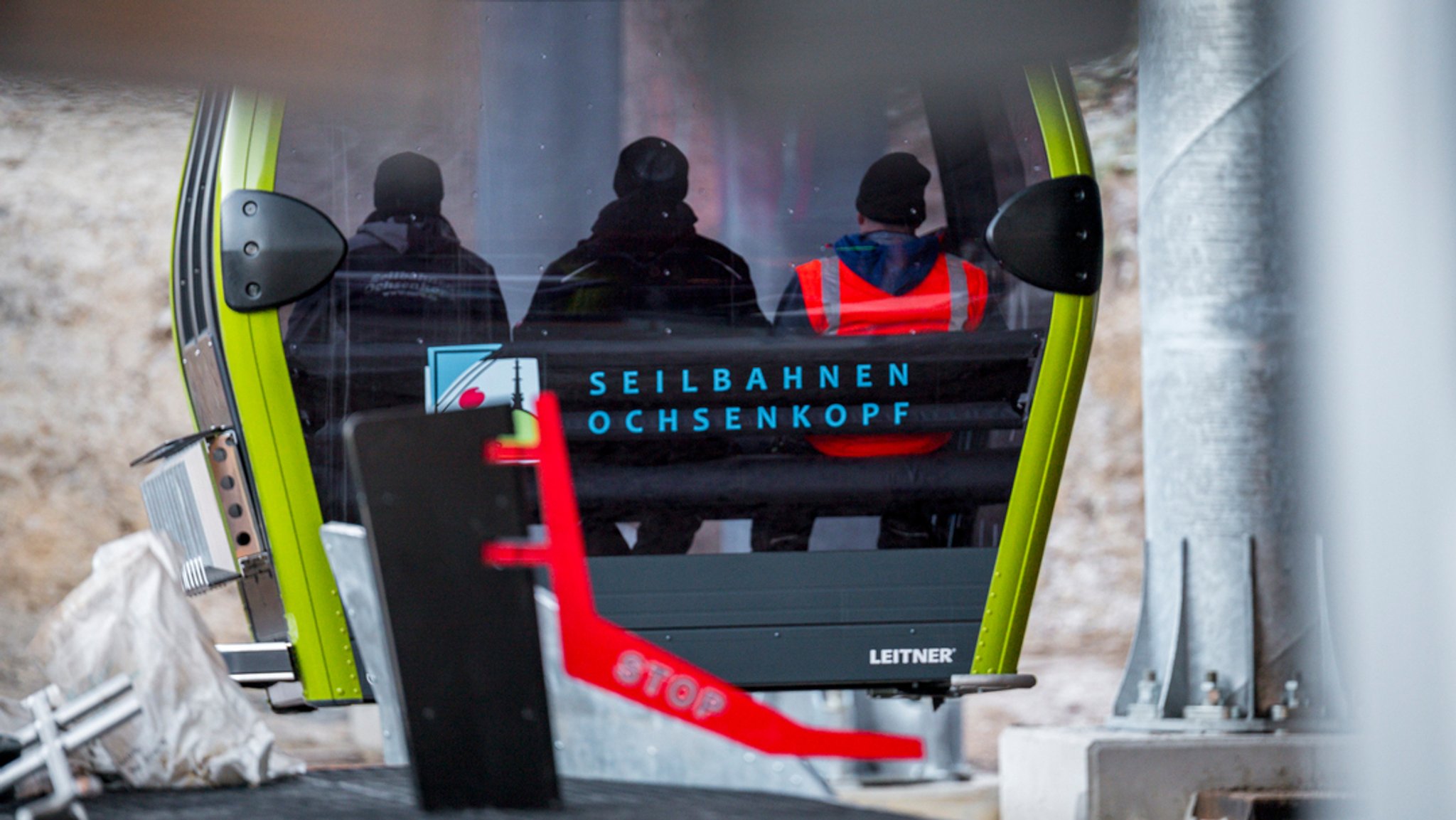 Drei Personen fahren in einer Gondel der neuen 10er Einseil-Kabinenumlaufbahn von der Talstation Nord zur Bergstation des Ochsenkopfs. 