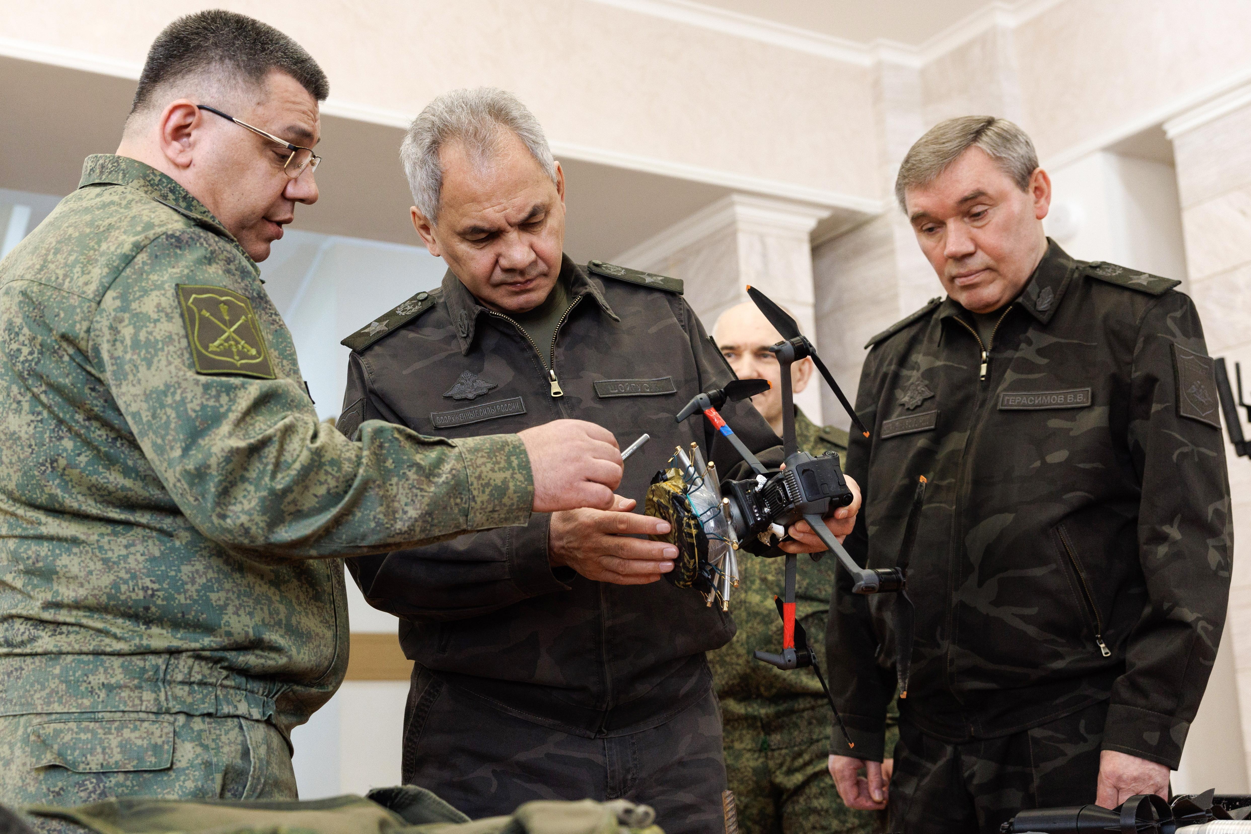 Die Beteiligten in Uniform mit einem Drohnenmodell, links Alexej Wolkow, Chef der Raketen- und Artillerietruppe