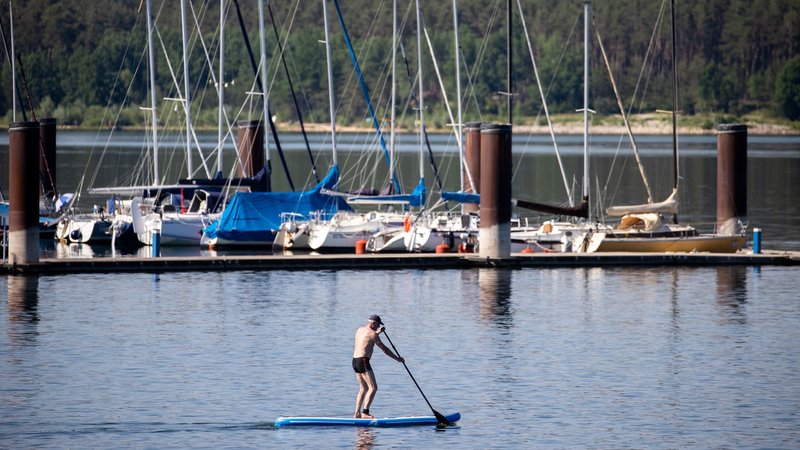 Fränkisches Seenland Yachthafen Ramsberg: Ein Mann gleitet mit einem Stand-Up-Paddle über den Brombachsee.