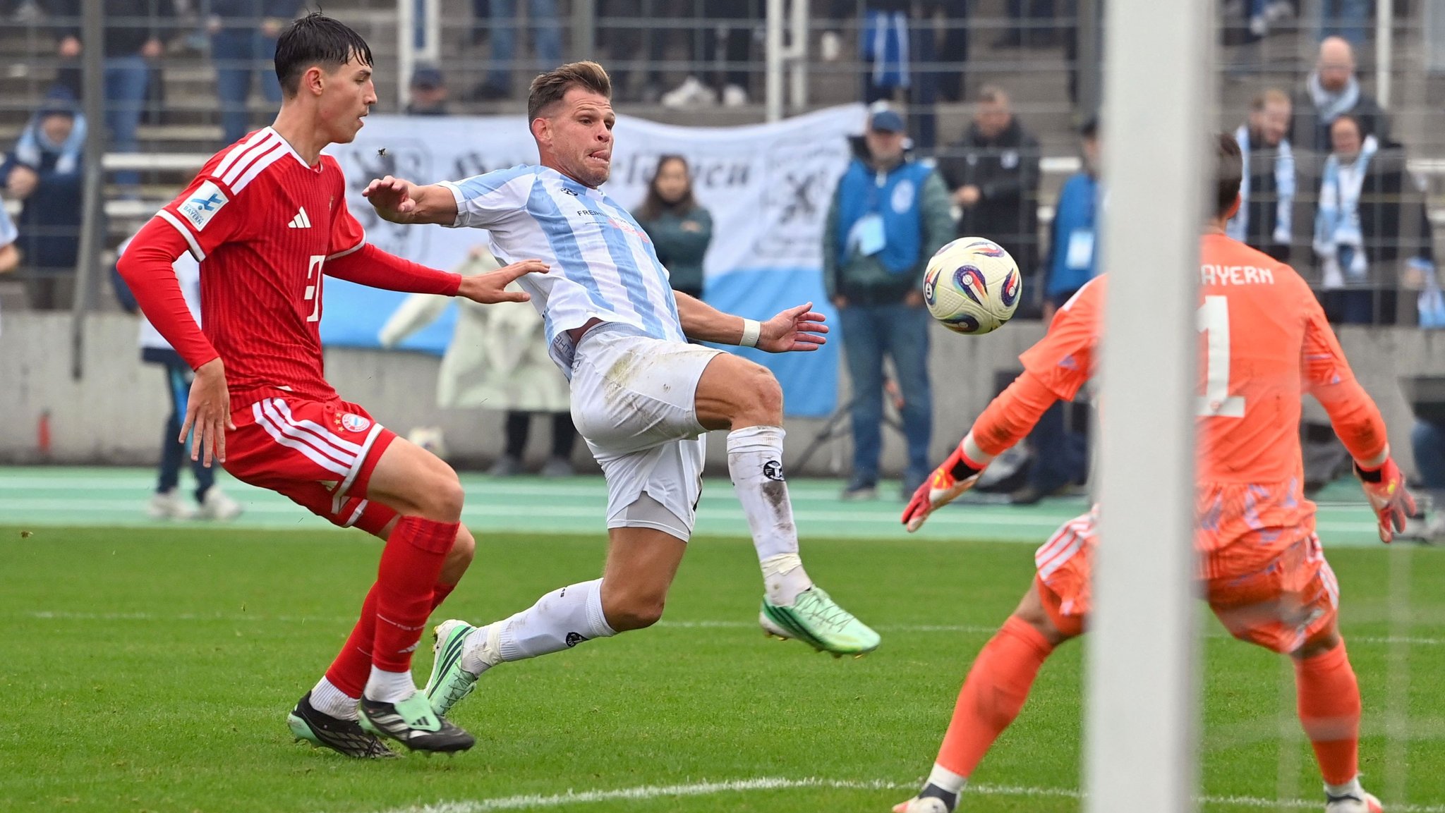 18.10.2026, Bayern, München: Fußball, Männer: Regionalliga Bayern, TSV 1860 München - Bayern München II, Fußball, Stadion an der Grünwalder Straße, Florian Niederlechner (M, 1860 München) versucht neben FIlip Pavic (l, Bayern München II) und Torwart Jannis Baertl (Bayern München II) an den Ball zu kommen. Foto: Frank Hoermann / SVEN SIMON/dpa +++ dpa-Bildfunk +++