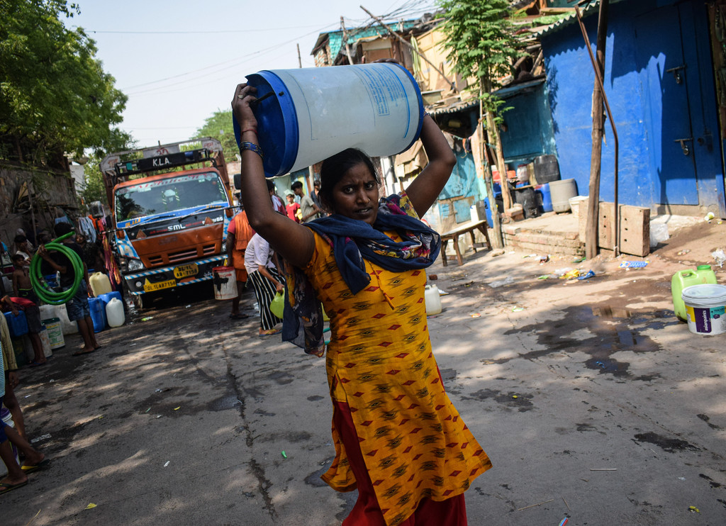 Hitzewelle in Indien: Eine Frau trägt Trinkwasser, das von einem Lkw gebracht wurde