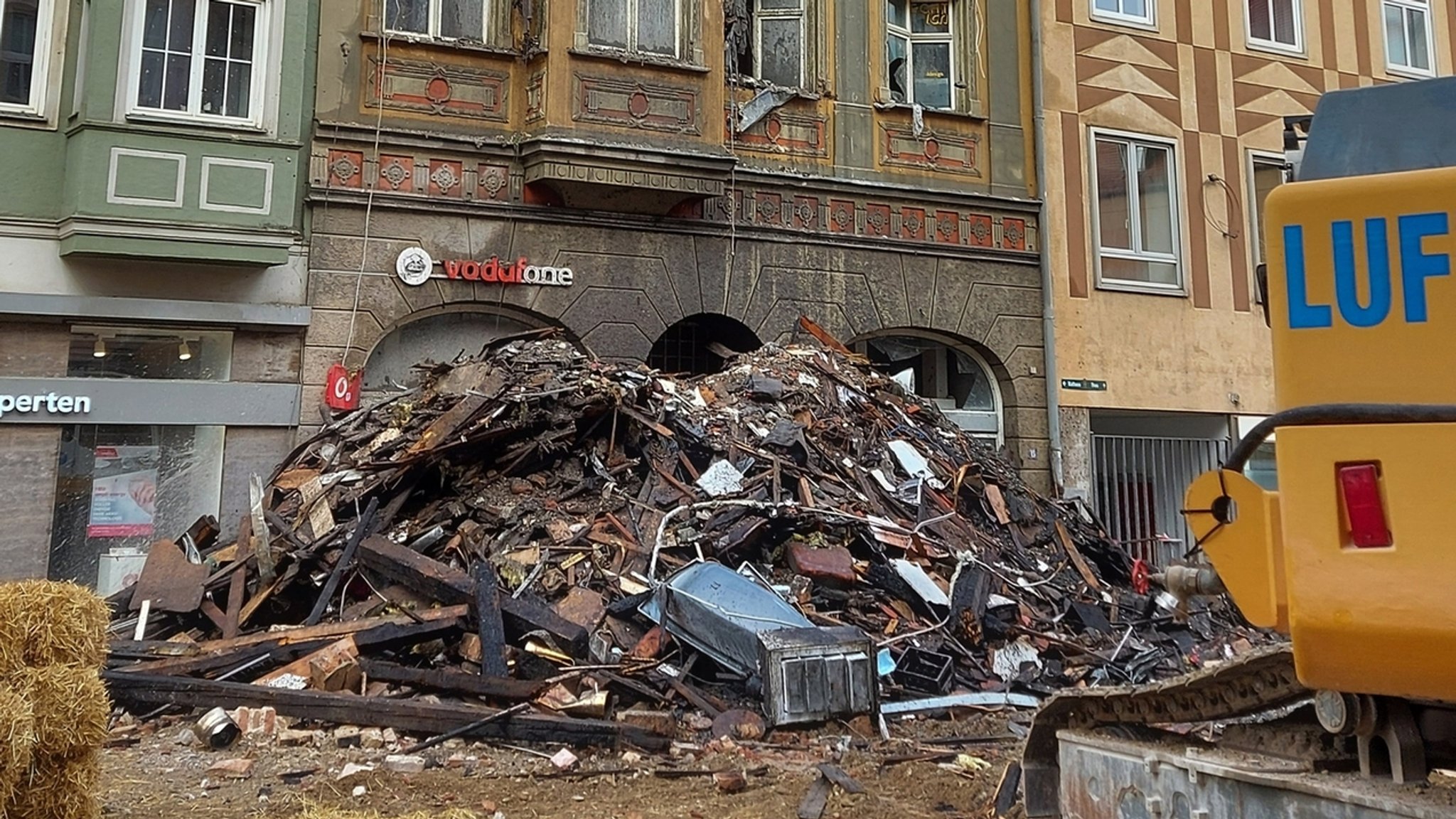 Bauschutt liegt vor dem abgebrannten Haus in der Augsburger Innenstadt