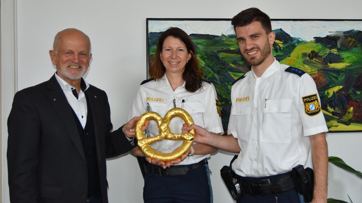 Nina Vallentin und Florian Lindner von der Münchner Polizei übergeben Oberbürgermeister Erich Raff  (links) die wiedergefundene Breze.