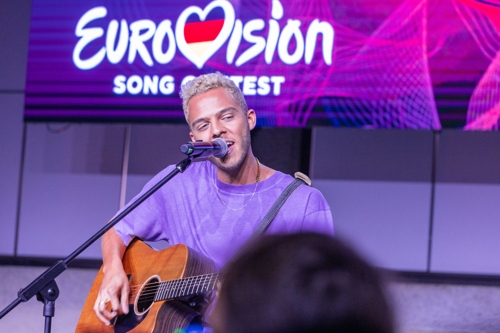 Malik Harris vor Eurovison Song Contest-Logo